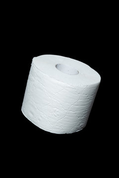 toilet paper on black background. Symbol image for corona crisis panic buying / hoarding, with copy space.