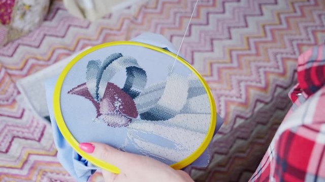 The woman is embroidering on hoop a picture. Home Crafts 4k