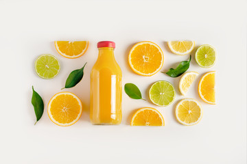 Fototapeta na wymiar Freshly squeezed juice in a bottle, scattered citrus fruits on the table. Design concept, top view