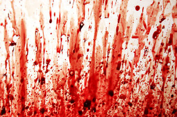 Splashes and smears of real clotted drop blood on a white surface.
