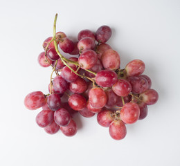 Fototapeta premium A bunch of pink large grapes on a white background. Studio photography