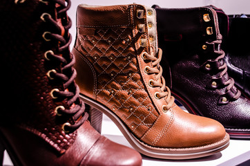 Fashionable leather women's boots on a shelf.