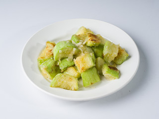 Fried young zucchini on a white plate. Side view