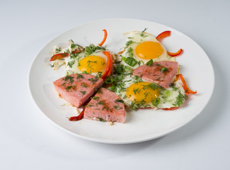 Fried sausage fried eggs on a white round plate. Side up