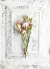 Dry carnation flowers on rustic wooden background. Flat lay. Still life