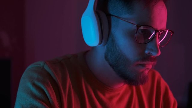 Close up portrait handsome man DJ playing music at home recording studio workshop. Student learns to write creative atmosphere music. Online education training. Sound beat maker. Colorful Neon light