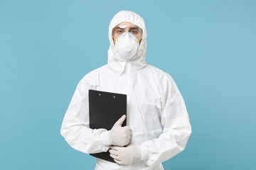 Man in white protective suit respirator mask hold clipboard with paper document isolated on blue...