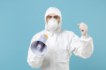 Man in white protective suit respirator mask scream in megaphone isolated on blue background studio. Epidemic pandemic new rapidly spreading coronavirus 2019-ncov medicine flu virus concept. Hurry up.