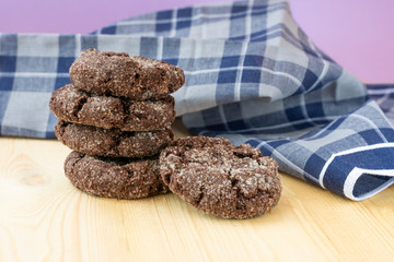 Group of homemade choco cookies on wooden table with dark blue towel. Biscuits on violet background.Ideas for ideal breakfast.