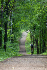 woman riding bicycle in forest