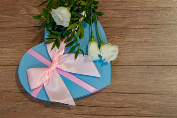 Heart box with beautiful flowers on wooden background.