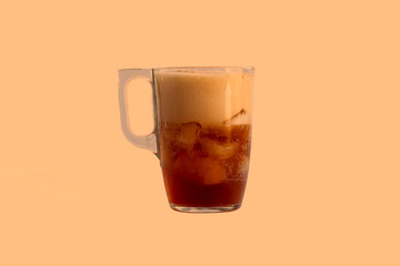 a mug is poured into it. Added ice cubes. Close-up. On coffee background.