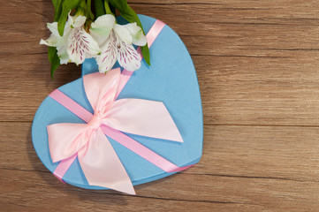 Heart box with beautiful flowers on wooden background.