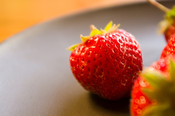 fresh ripe berries strawberries on black ceramic plate, close up