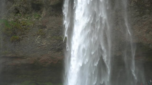 Gljufrabui, Iceland - May 2019: Closeup of Gljfrafoss waterfall with unidentified tourists walking, Iceland
