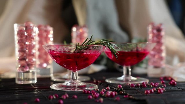 beautiful red cocktail in a martini cocktail glass, cocktail with rosemary and rose petals