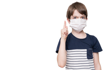 Portrait of kid with face mask pointing finger up, isolated on white background