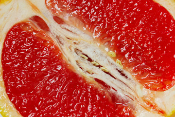 Blurry image of red grapefruit texture, close up. Colorful food background. Fruits, healthy food concept.
