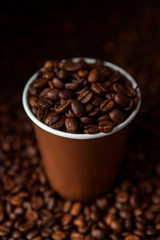 Take away black coffee cup with roasted coffee beans. Space for application logo