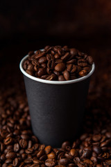 Take away black coffee cup with roasted coffee beans. Space for application logo
