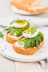 Fototapeta na wymiar Toast with avocado, arugula and egg. Healthy Breakfast.