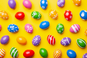 Flat lay composition with Easter eggs on color background. Pattern made of decorated eggs. Top view