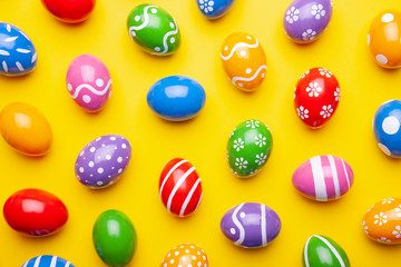 Flat lay composition with Easter eggs on color background. Pattern made of decorated eggs. Top view