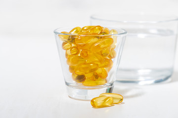 dietary supplement - fish oil capsules in a glass