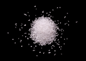Pile of salt close-up. Salt crystals on a black background. A mound of salt on a black background.