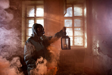 Dramatic portrait of a woman wearing a gas mask in a ruined building.