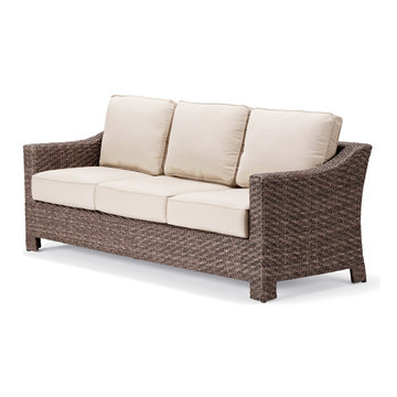 Outdoor Weave Sofa Isolated on White Background. Side View of Patio Wicker Dining Sofa with Beige Fabric Cushion Seat and Spread Pillows. Outdoor Rattan Furniture. Metal Arm Sofa