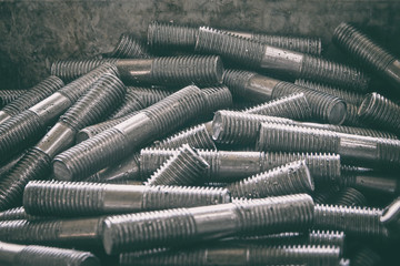 lot of metal studs with threads are in a plastic box