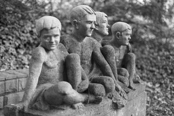 Szczecin, cemetery tombstone, sculpture of four sitting boys.