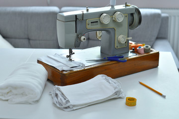 Homemade medical mask in the process. Sewing virus face mask at home. Detail on sewing machine.