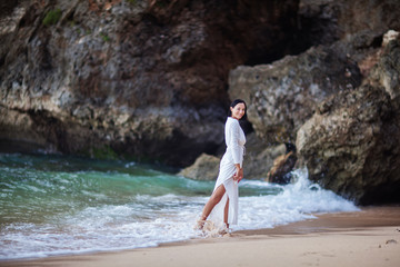 Beautiful woman by the ocean at sunset