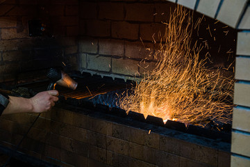 Cooking on fire in a restaurant. Cook inflates the coals. flying sparks