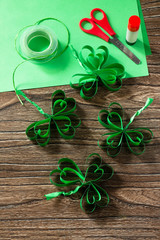 Patrick's Day Clover, craft paper on wooden table. Handmade. Children's art project, needlework, crafts for children.