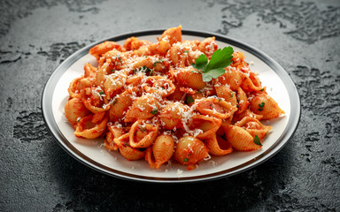Conchiglie rigate pasta with chickpeas in tomato sauce with parmesan cheese. Healthy vegan food.