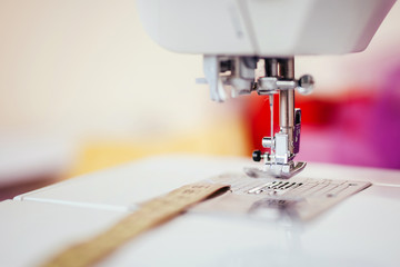 Presser foot with needle on a sewing machine with blurred background
