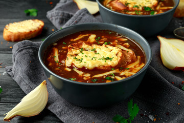 French onion soup with cheese toast on rustic background