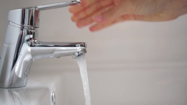 Persona lavando las manos para desinfectar y prevenir la infecci&oacute;n de corona virus con agua y jab&oacute;n en el ba&ntilde;o 4k