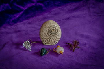 Stone with Triskel symbol and four crystal dowsing pedulums