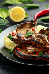 Homemade Grilled Pork loin chops in lemon sauce with herbs on rustic wooden table