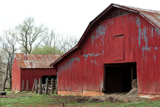 A traditional red barn on a large farm.