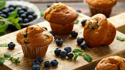 Blueberries muffins, cupcake with mint and berry on wooden board.