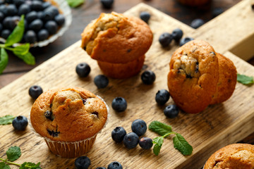 Blueberries muffins, cupcake with mint and berry on wooden board.