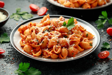 Conchiglie rigate pasta with chickpeas in tomato sauce with parmesan cheese. Healthy vegan food.