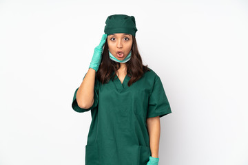 Surgeon woman in green uniform isolated on white background has just realized something and has intending the solution