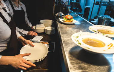 Waiters pick up ready meals in a restaurant at the counter for dispensing dishes