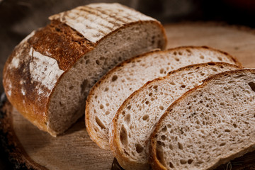 Freshly baked bread cut into chunks on a wooden Board